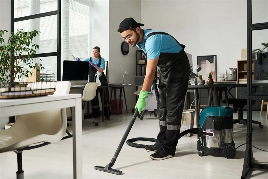 Professional cleaner vacuuming a living room